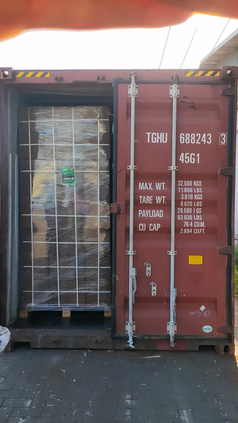 View into a loaded container from the open doors, with wrapped pallets of cocopeat blocks stowed inside.
