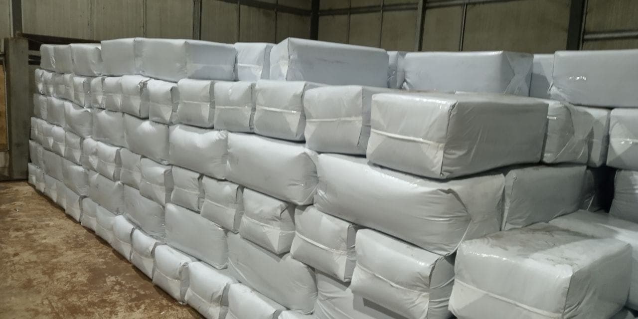 Wrapped white bales of coco husk chips stacked ready for despatch.